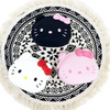 Twinkle Glory Hello Kitty Mimi Pochi silicone pouches in white, black, and pink on a patterned circular mat