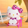Twinkle Glory Hello Kitty PVC figure sitting in a pink beach chair with a leopard print bow on a sandy beach