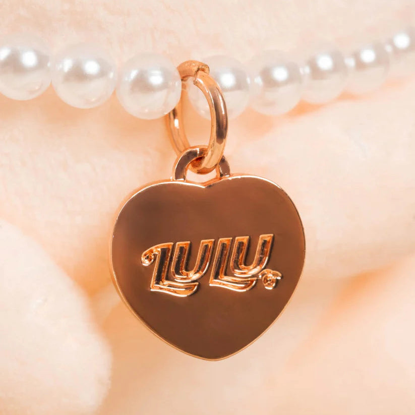 Heart-shaped pendant with 'LULU' engraving on a pearl necklace, TOYZERO+ brand visible