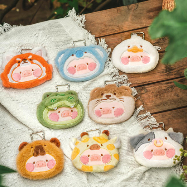 Set of plush animal keychains on a wooden surface with a blurred natural background