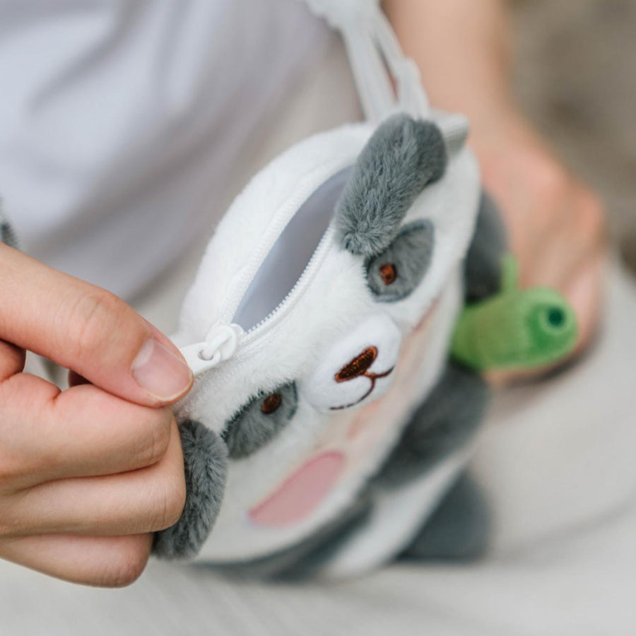 Plush panda toy held by a person with a blurred background