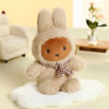 Plush toy rabbit with a bow tie sitting on a white surface in a cozy room.
