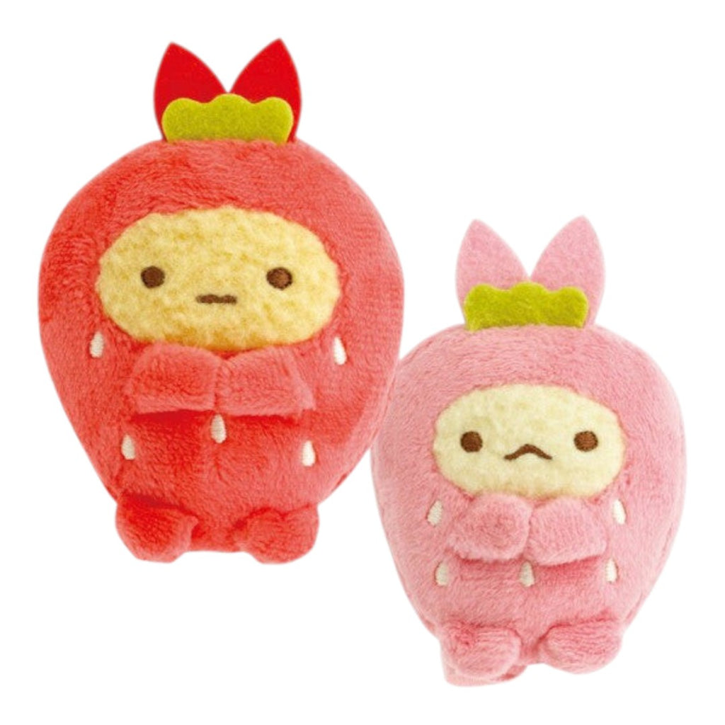 Two cute plush character toys shaped like round characters in red and pink outfits, each with a yellow face and small green leaf accents on top, shown on a plain white background.