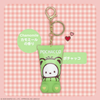 Pochacco keychain with green packaging on a pink checkered background
