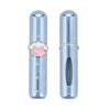 A light blue metallic lip gloss tube shown in two views: one closed with a cute character charm in the center, and one open showing the applicator window.