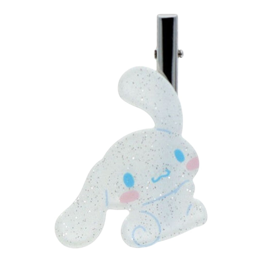 A Cinnamoroll-shaped hair clip with a glittery white translucent body, blue facial details, and pink cheeks, attached to a silver metal spring clip on a plain white background.
