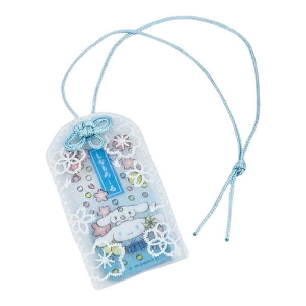 A Sanrio Cinnamoroll luggage tag with a light blue cord, decorated with white lace, pastel flowers, and a blue tag insert.