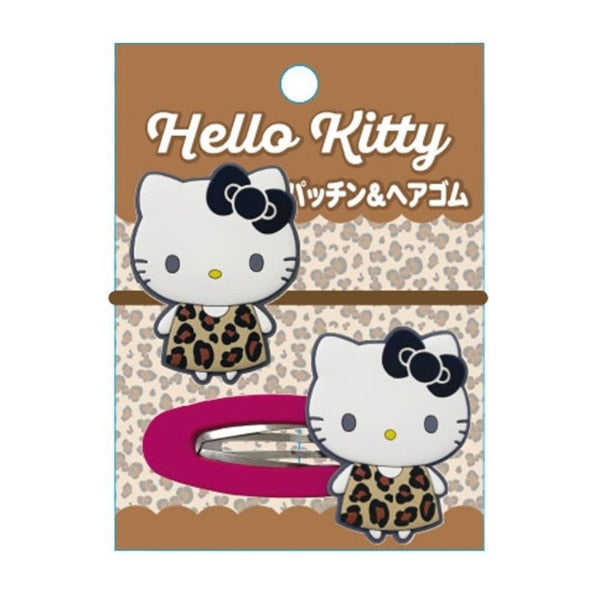 Hello Kitty hair clip and matching headband set on a brown leopard-print backing card. The set includes a silver-toned metal hair clip with a pink headband, both featuring Hello Kitty in a leopard-print dress and black bow.