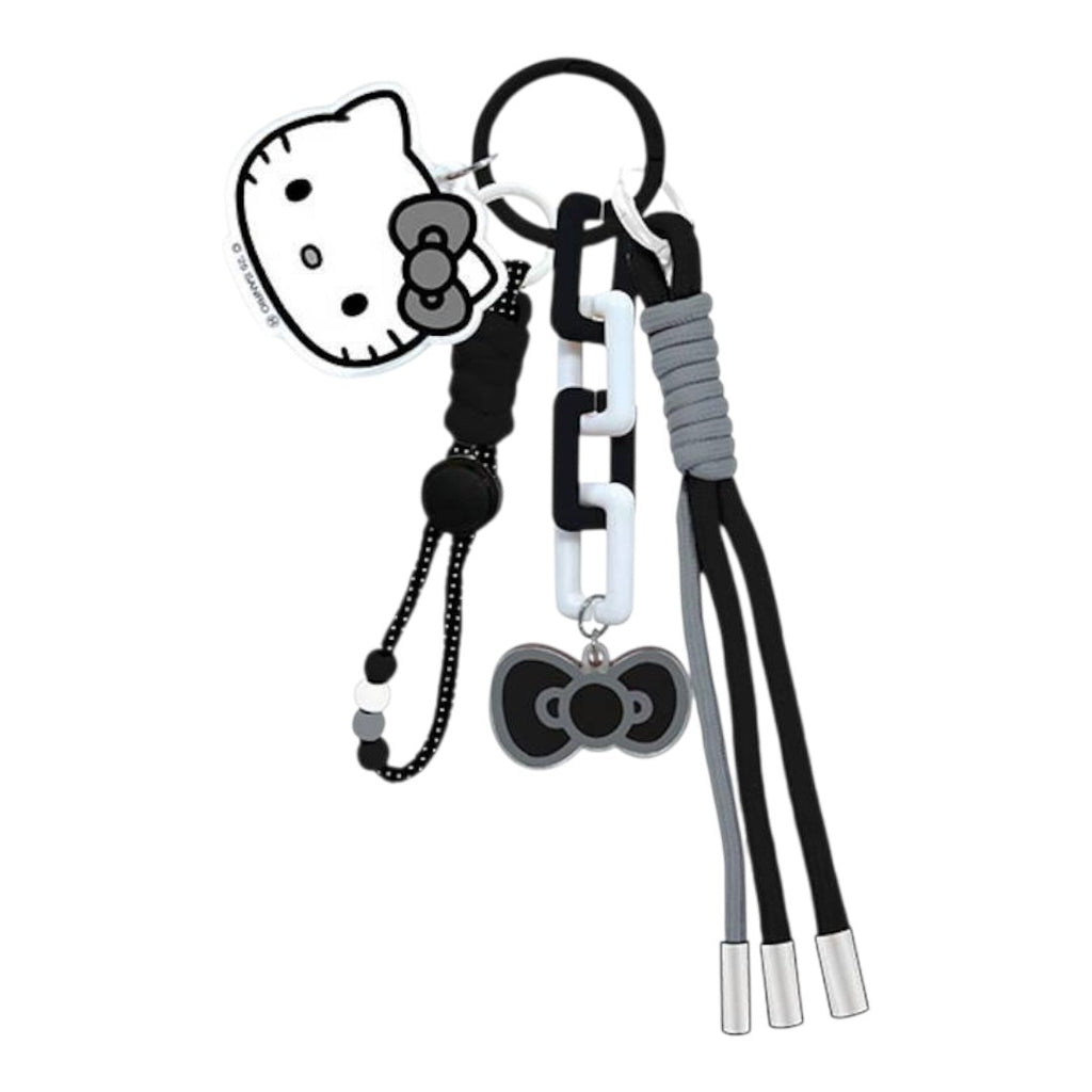 A black and white Hello Kitty keychain set featuring a Hello Kitty face charm, a black bow charm, a black and white chain link, a gray wrapped cord, and three dangling black and gray cords with silver tips, all attached to a black key ring on a white background.