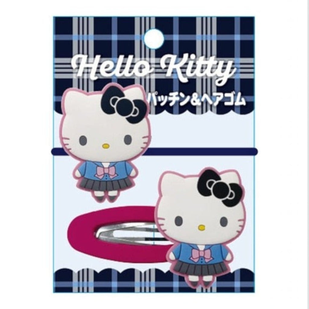 Hello Kitty hair accessory card featuring a pink and blue plaid design, with two Hello Kitty character clips and a silver metal hair clip visible on the packaging.