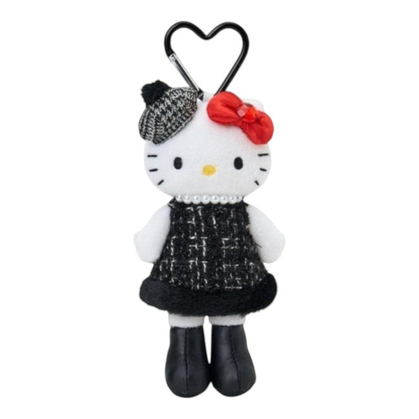 A Hello Kitty plush keychain accessory featuring a white plush face with black eyes and whiskers, wearing a black and white tweed dress, a red bow, and a black-and-white patterned beret, attached to a black heart-shaped carabiner on a plain white background.