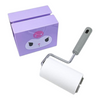 A small cleaning roller with a white lint roller body and gray handle, shown next to a lavender box featuring a cartoon face.