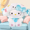 Twinkle Glory Hello Kitty plush bag charm wearing a fluffy white puppy hat with blue bow and collar on a sofa