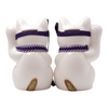 Back view of two Twinkle Glory Goenneko ceramic lucky cats with purple headbands and gold tails on a white background