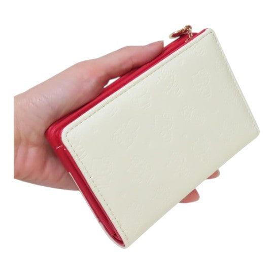 Twinkle Glory Hello Kitty cream zipper wallet with embossed character pattern held in a hand