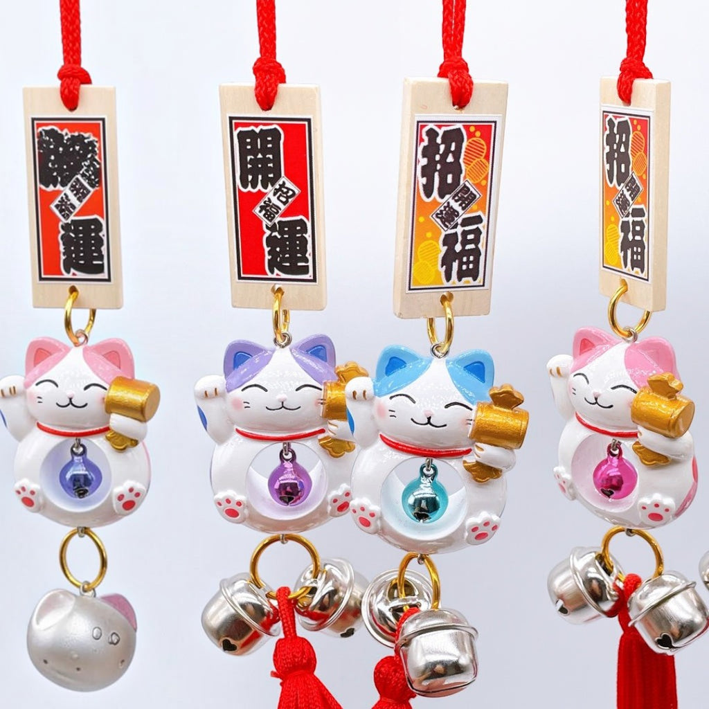 Twinkle Glory Japanese lucky cat charms in purple, blue, pink, and yellow resin with hanging bells and red cords.