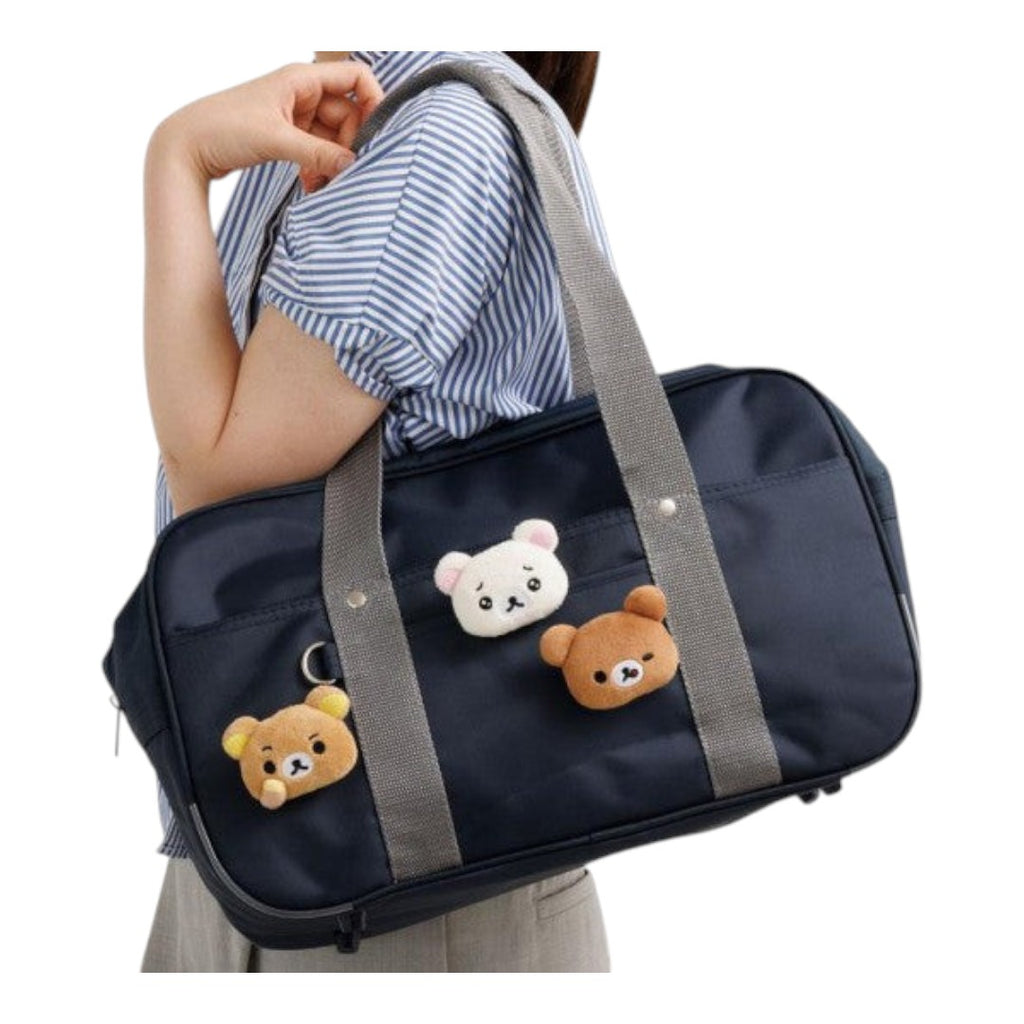 Twinkle Glory San-X Kiiroitori plush badge with grumpy face attached to a navy blue shoulder bag