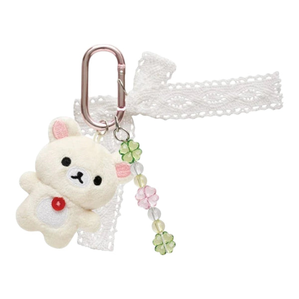 Twinkle Glory San-X Korilakkuma plush keychain with a white lace bow, clover beads, and a pink carabiner clip.