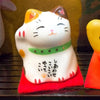 Twinkle Glory Japanese Six Blessings Maneki Neko ceramic cat figurine with traditional calligraphy on a red cushion