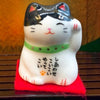 Twinkle Glory Japanese Six Blessings Maneki Neko ceramic cat figurine with black and white markings on a red mat
