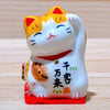 Twinkle Glory Yakushigama mini ceramic lucky cat figurine with orange and white markings and a raised paw