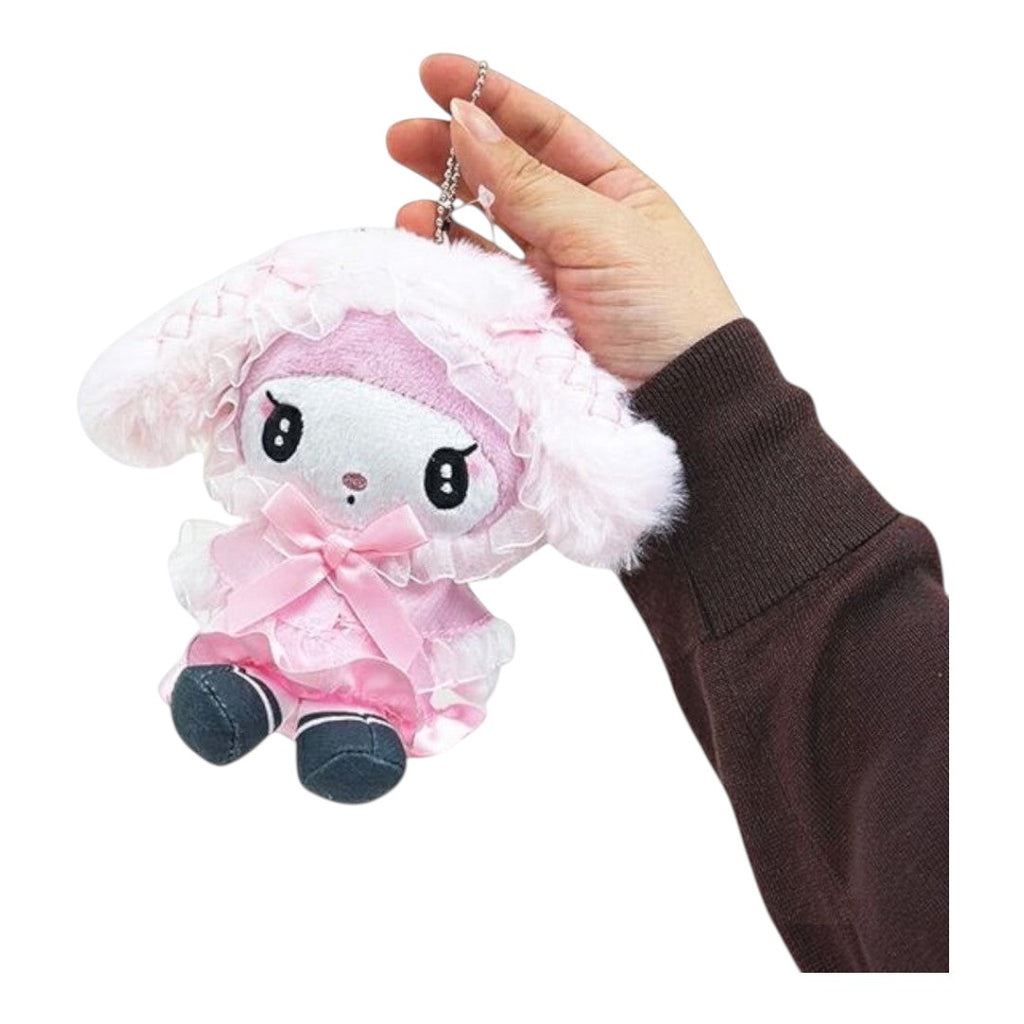 Twinkle Glory My Melody plush cape pouch keychain in soft pink polyester with a bow and lace trim held by a hand