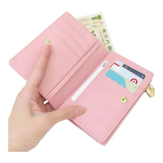 Twinkle Glory pink My Melody bi-fold wallet held in hand showing card slots and cash compartment