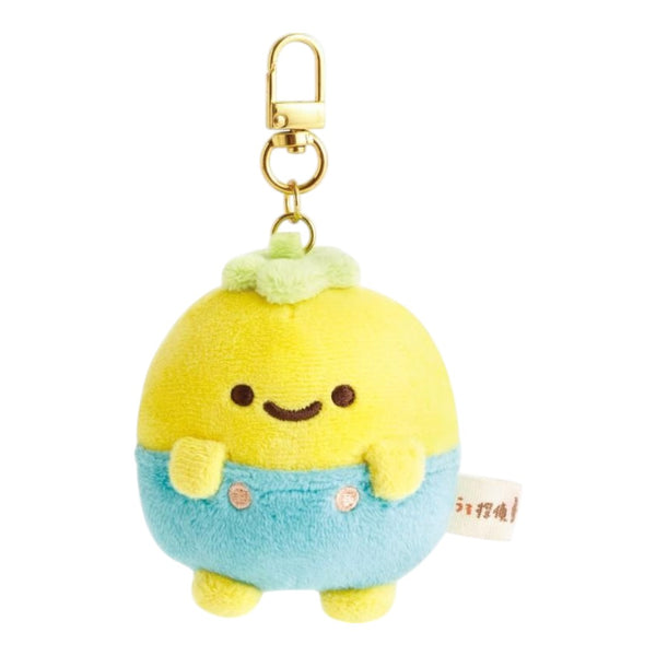 Twinkle Glory San-X Pucchy plush keychain with yellow head, blue overalls, and gold clip on a white background