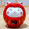 Twinkle Glory small red porcelain Daruma lucky cat figurine with hand-painted details and a smiling face.