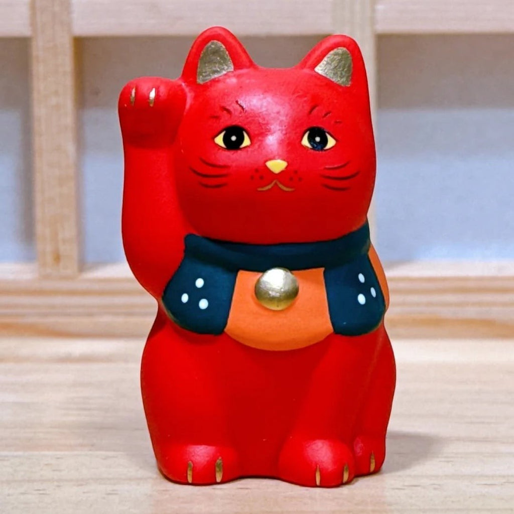 Twinkle Glory Yakushigama red porcelain Maneki-Neko lucky cat figurine with a dark collar and gold accents