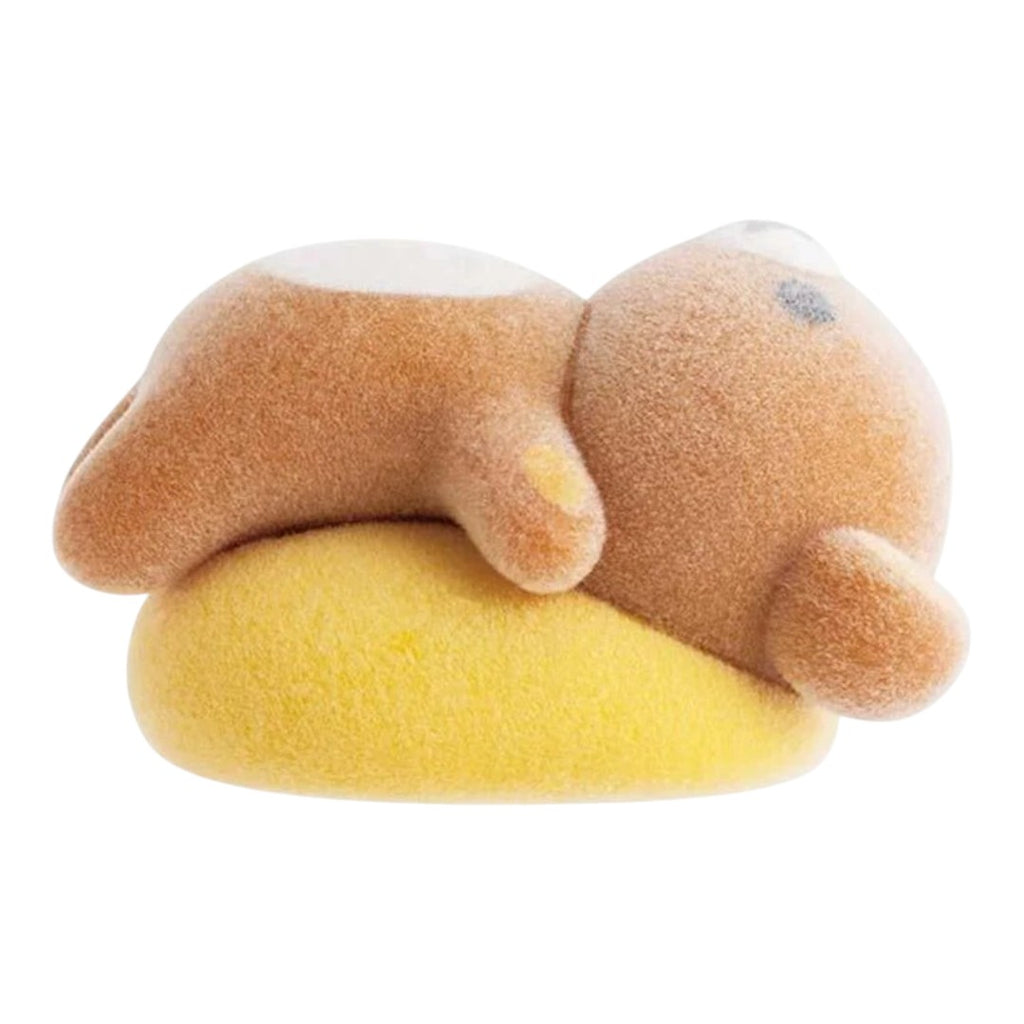 Twinkle Glory San-X Rilakkuma flocked bear figure lying on a yellow cushion, featuring a soft velvety texture.