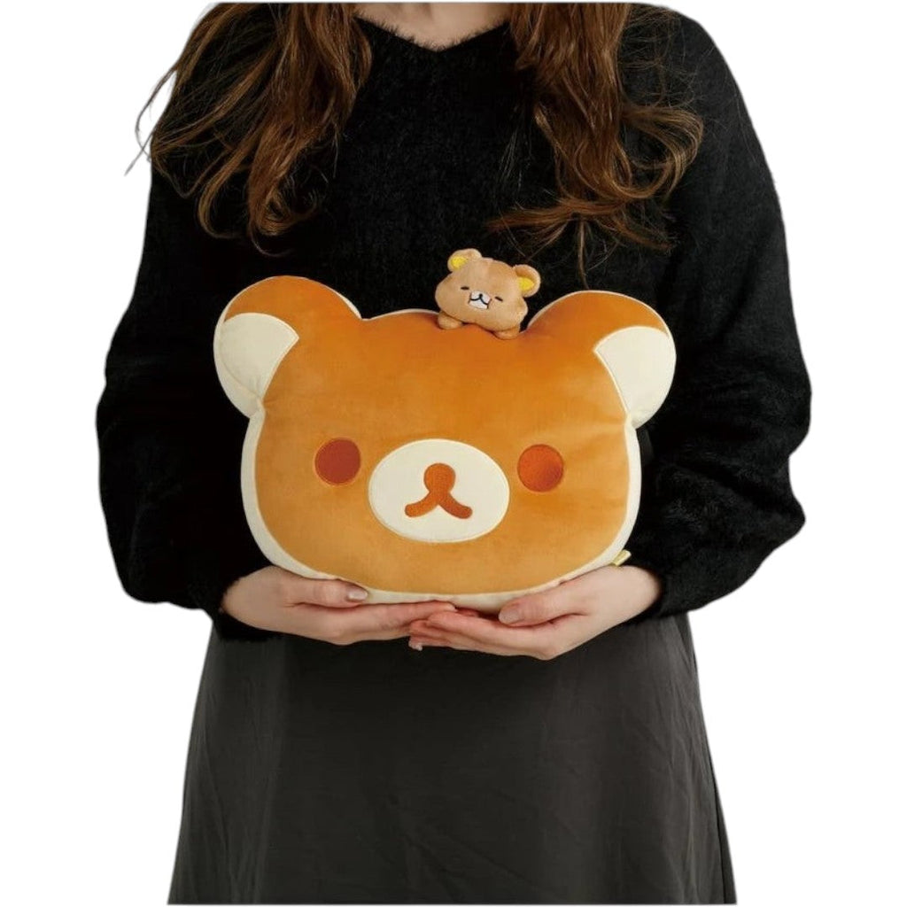 Twinkle Glory San-X Rilakkuma super mochi mochi plush pillow held by a person, featuring a soft tan bear face design.