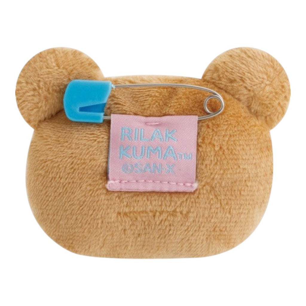 Twinkle Glory San-X Rilakkuma plush badge back view showing the blue safety pin and branded fabric tag