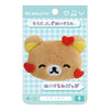 Twinkle Glory San-X Rilakkuma plush badge featuring a brown bear face with red heart accents on a display card