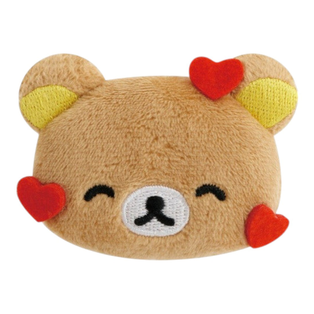 Twinkle Glory San-X Rilakkuma plush badge featuring a brown bear face with red heart accents and a pin-back clip.