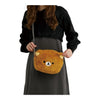 Twinkle Glory Rilakkuma plush face-shaped shoulder bag in brown polyester worn cross-body by a woman in black dress.