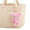 Twinkle Glory San-X Rilakkuma plush keychain in cherry blossom pink with sakura flower details attached to a tote bag