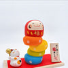 Twinkle Glory Ryukodo porcelain Daruma Otoshi stacking game with a hand-painted lucky cat on a red cloth and wood base