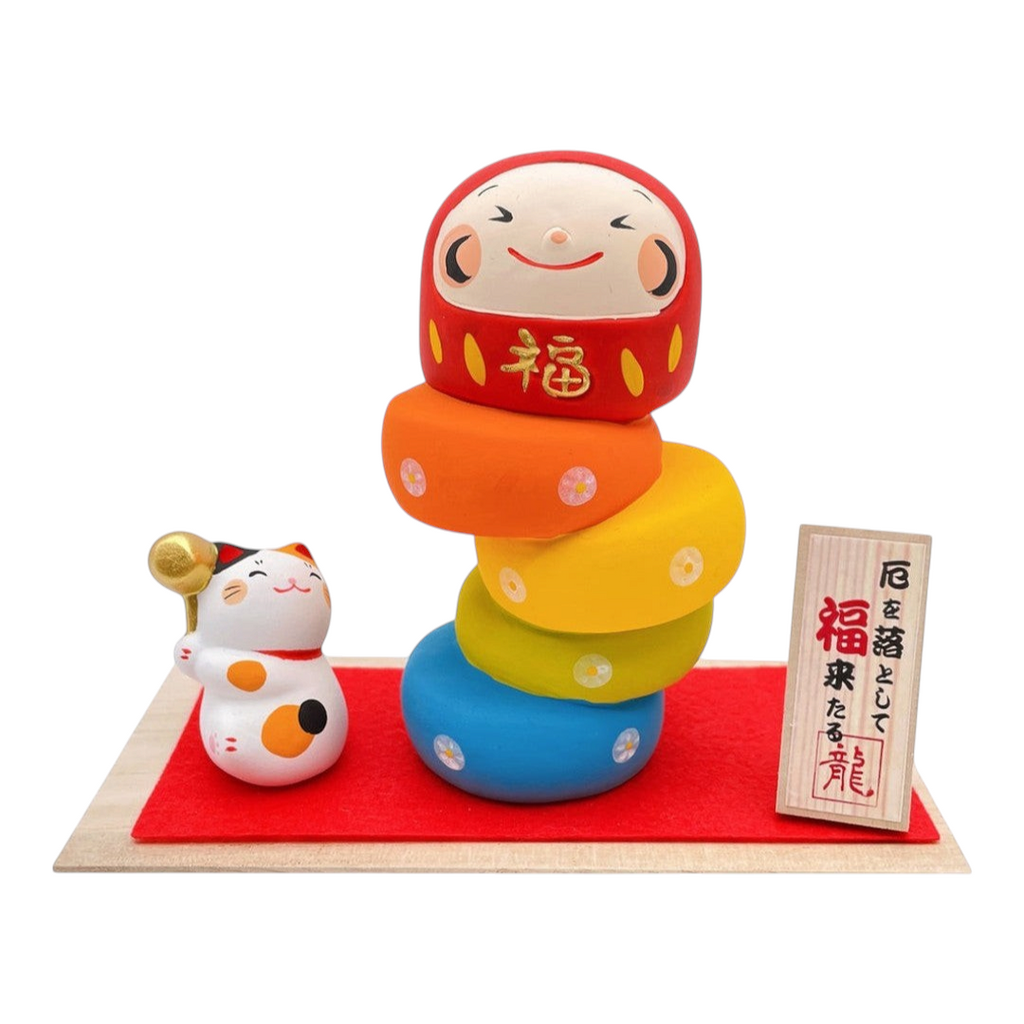Twinkle Glory Ryukodo porcelain Maneki Neko lucky cat and colorful Daruma Otoshi stacking game set on a red cloth.