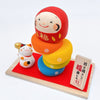 Twinkle Glory Ryukodo porcelain lucky cat and colorful Daruma Otoshi stacking game set on a red cloth and wooden base