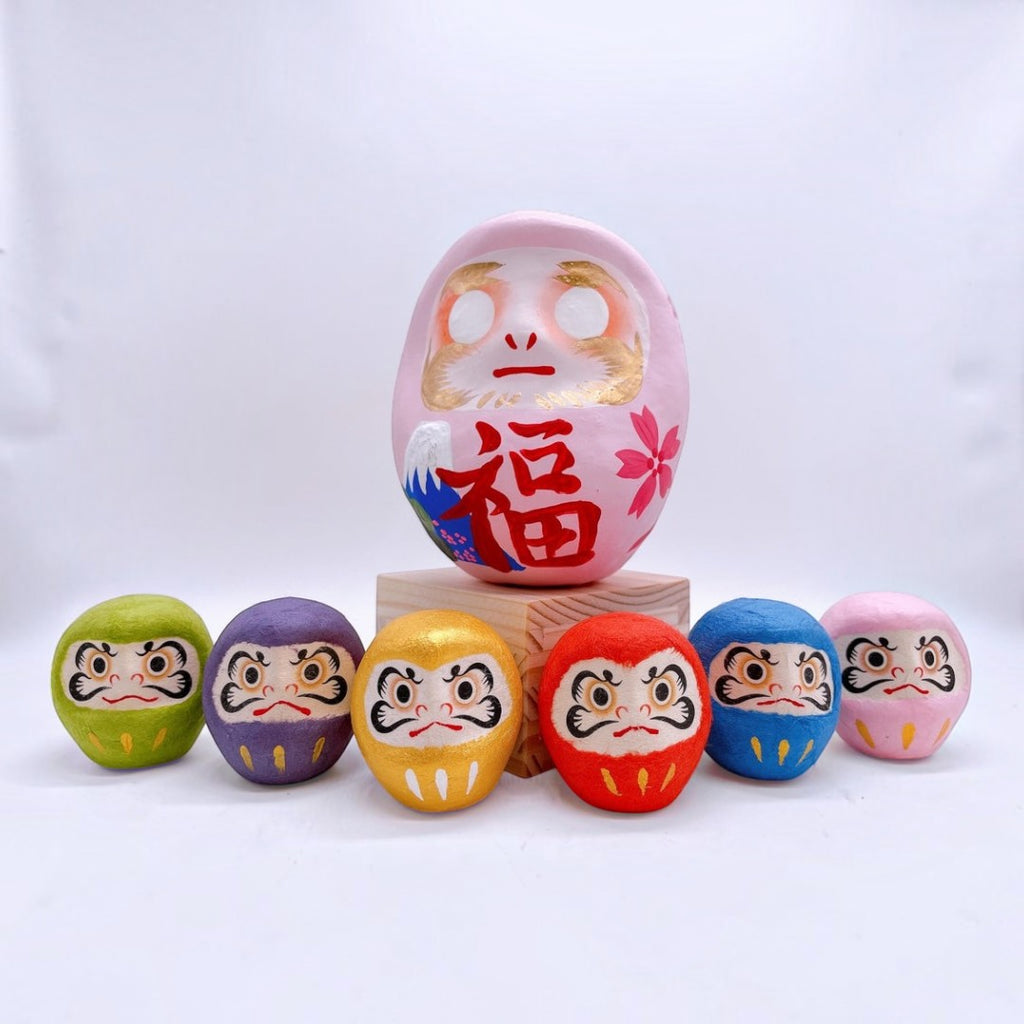 Twinkle Glory Japanese six-color paper Daruma dolls featuring a large pink centerpiece and smaller colorful figures.