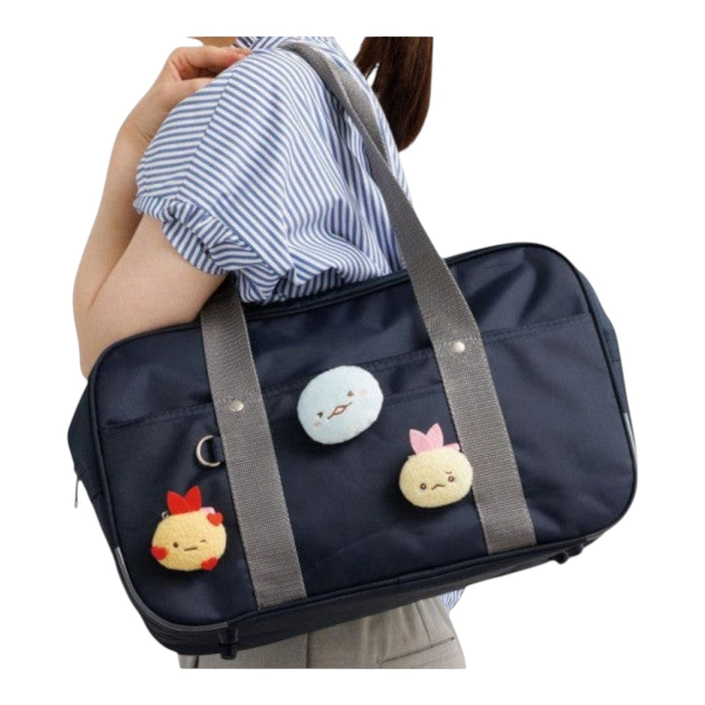 Twinkle Glory San-X Sumikko Gurashi Tokage plush badge attached to a navy blue school bag