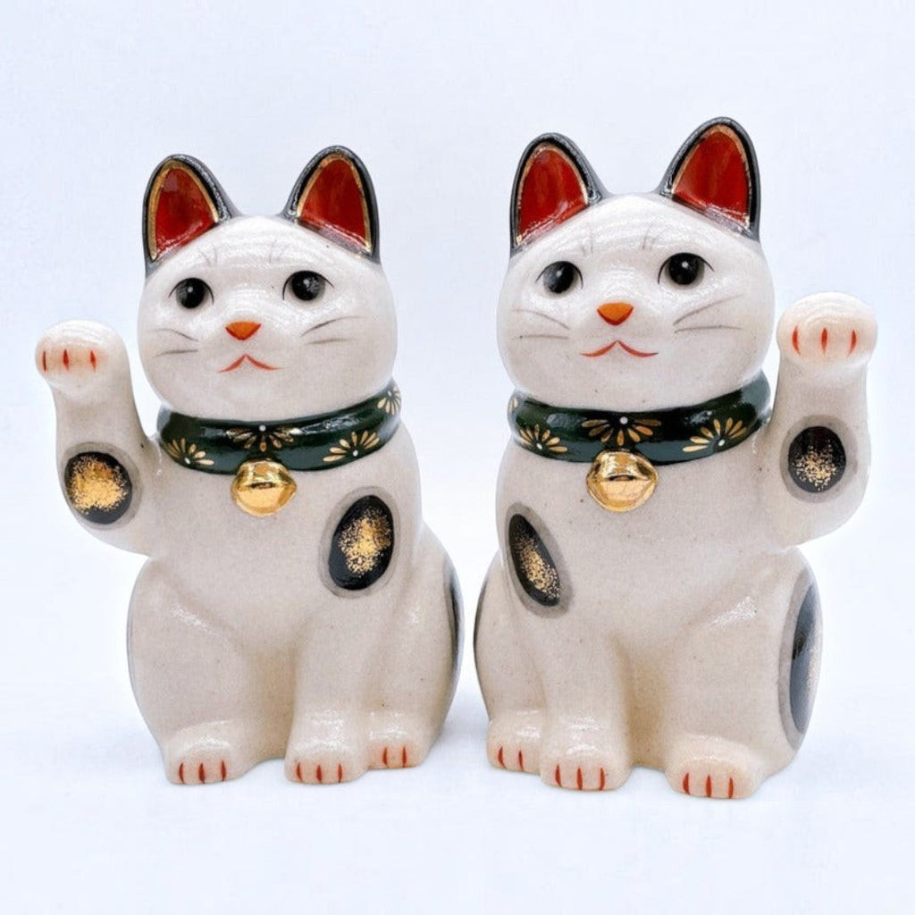Twinkle Glory Yakushigama ceramic lucky cat pair with green chrysanthemum collars and golden bells on white background