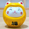 Twinkle Glory small yellow porcelain Daruma lucky cat figurine with hand-painted details and a smiling face