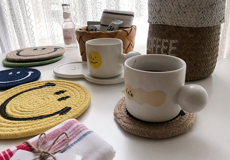 Mug of coffee on a brown Smiley Face coaster