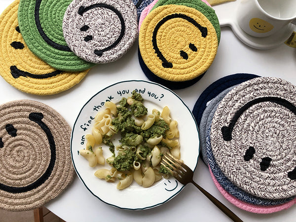 A variety of different coloured Smiley Face mat coasters next to a plate of food