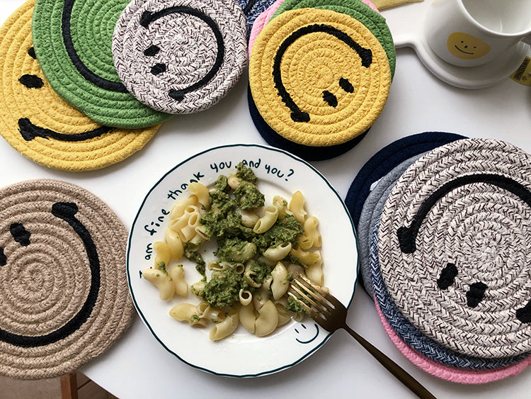A variety of different coloured Smiley Face mat coasters next to a plate of food