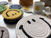Several stacks of differently coloured Smiley Face mat coasters