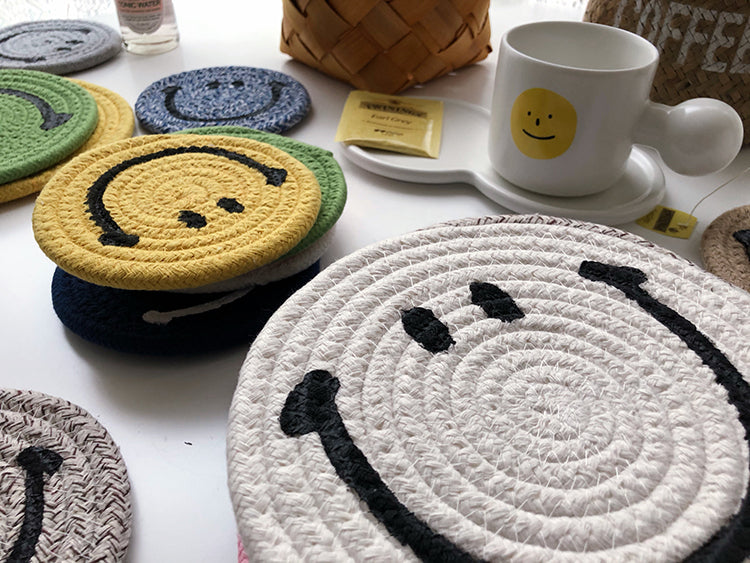 Several stacks of differently coloured Smiley Face mat coasters