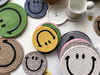 Stacks of different coloured Smiley Face mat coasters
